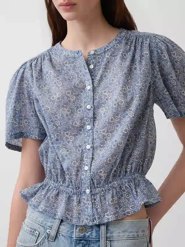 Blusa corta con peplum y cierre frontal de botones